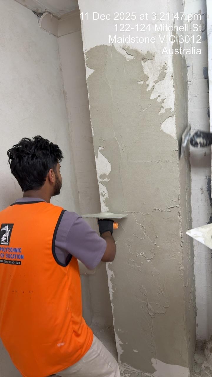 Naimul Islam Manna applying solid plaster to an interior column